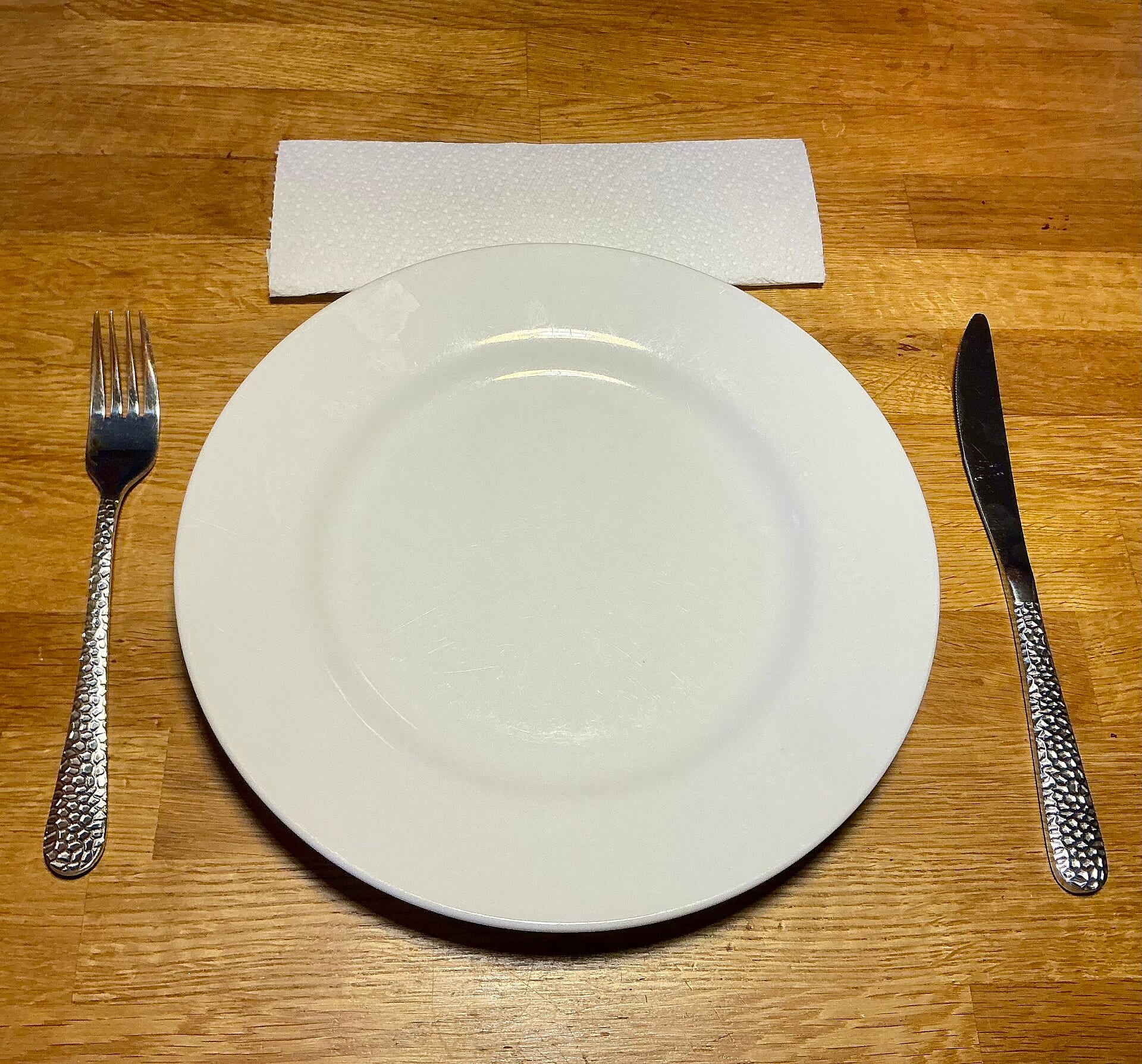 A plate, fork and knife on a wooden table