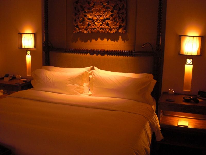 A bedroom at night with bedside lamps lit